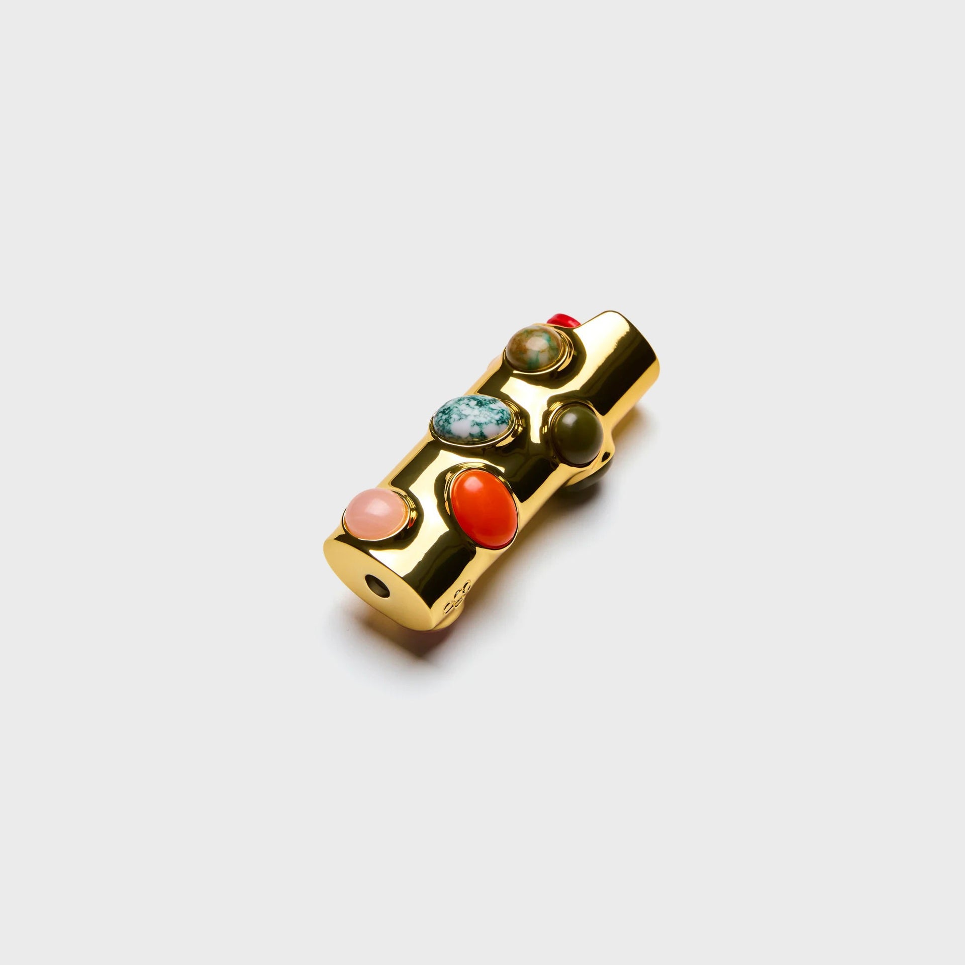 Edie Parker Stoned lighter case in gold, angled view with coral, pink and green cabochon stones and red lighter top