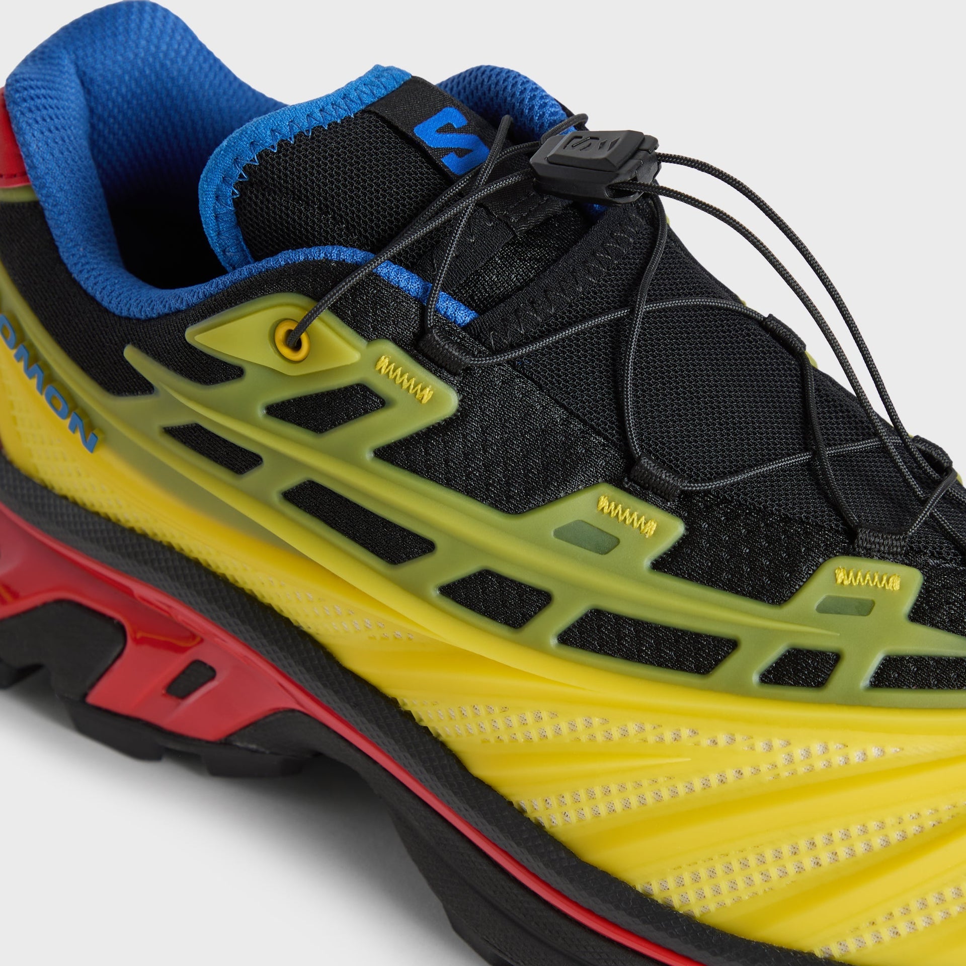 Kith for Salomon XT-EVO detail, lateral quick-lace toggle and yellow midsole chassis with SALOMON logo