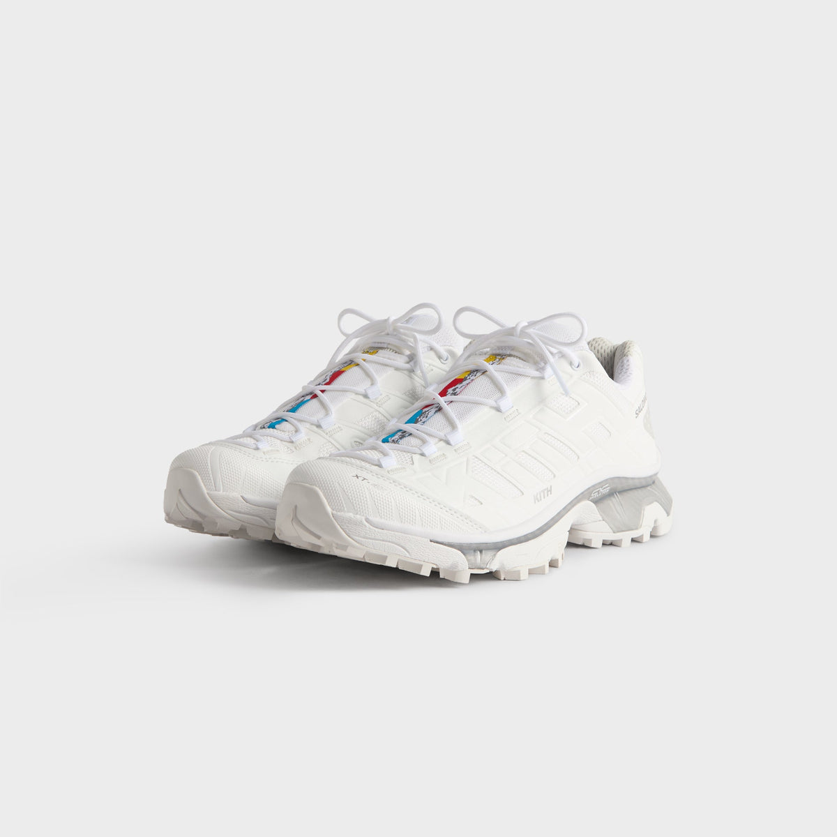 Kith for Salomon XT-4K in White, front three-quarter view of the pair showing multicolor lace-panel accents and quicklaces