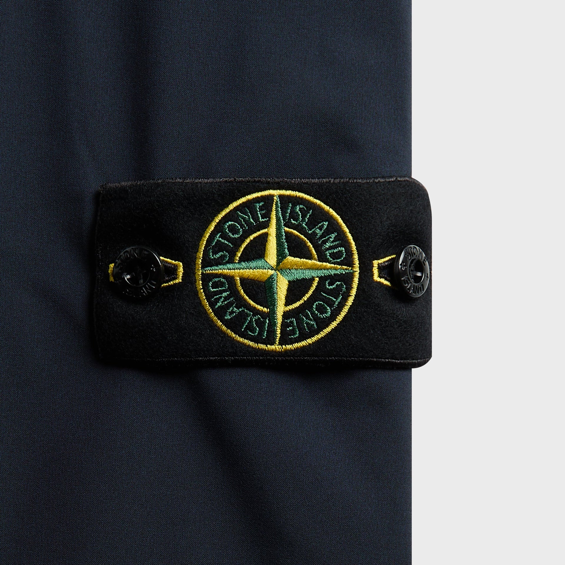 Close-up of navy Soft Shell trouser compass badge patch with buttoned tab