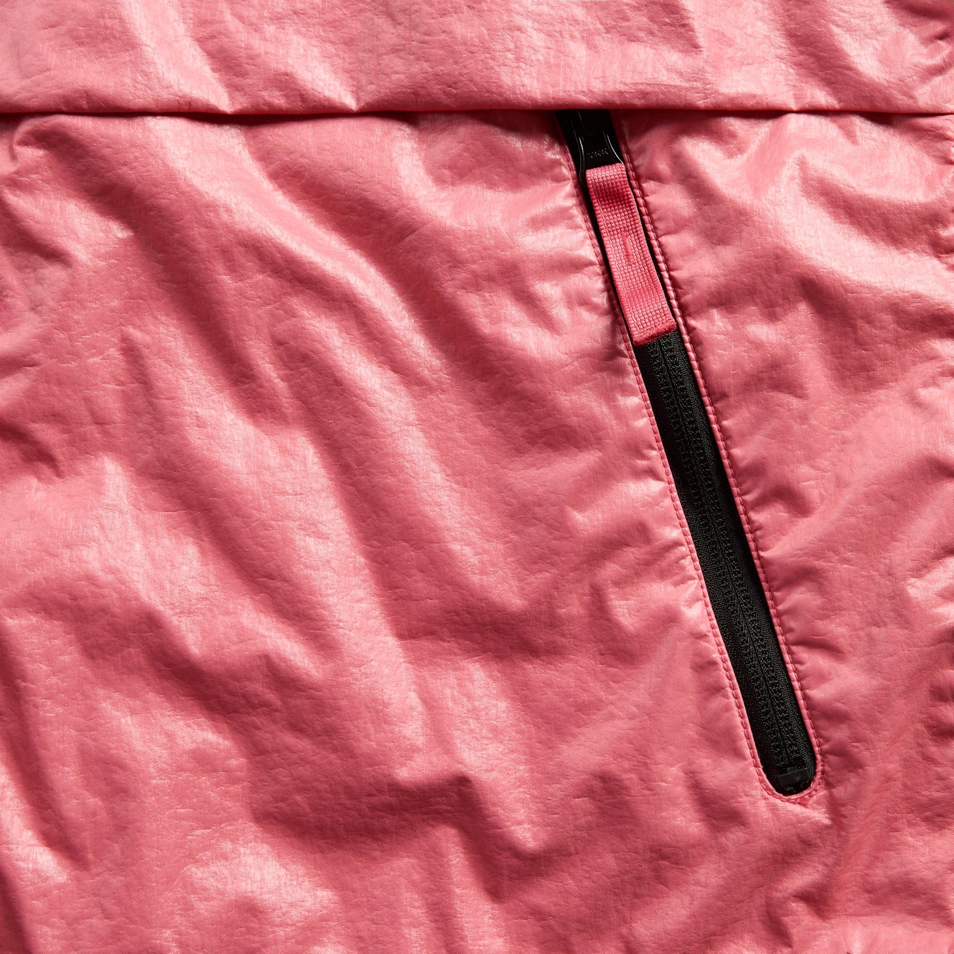 Detail of black waterproof zip pocket with pink pull on geranium metallic nylon jacket