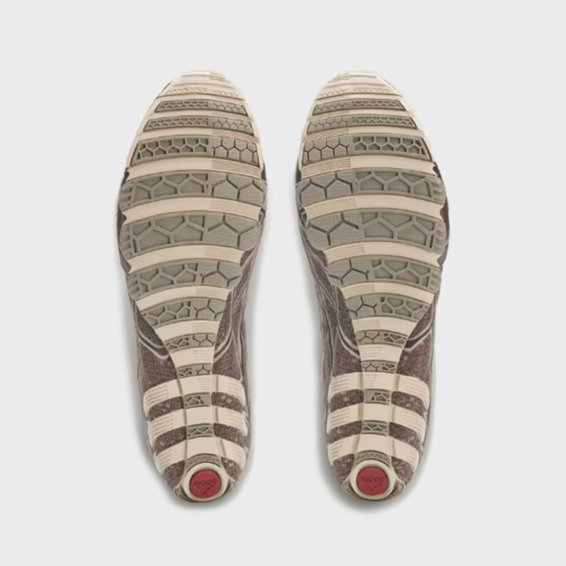 Outsole view of adidas x Bad Bunny F50 Ghost Sprint sneakers showing honeycomb tread and burgundy heel accent