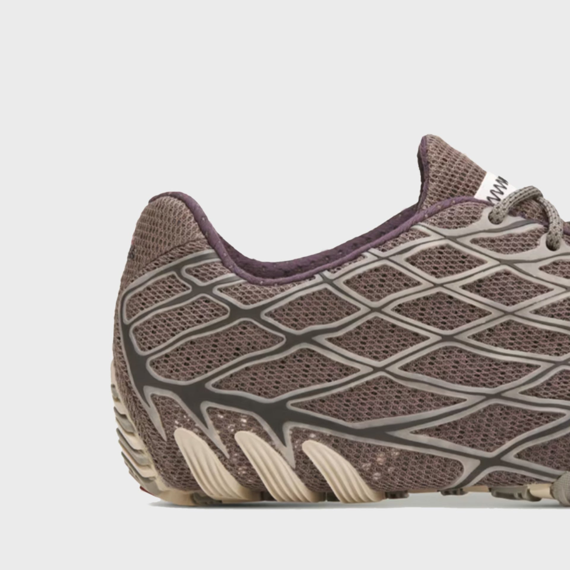 Close-up of adidas x Bad Bunny F50 Ghost Sprint heel counter and lace webbing in taupe mesh with plum trim