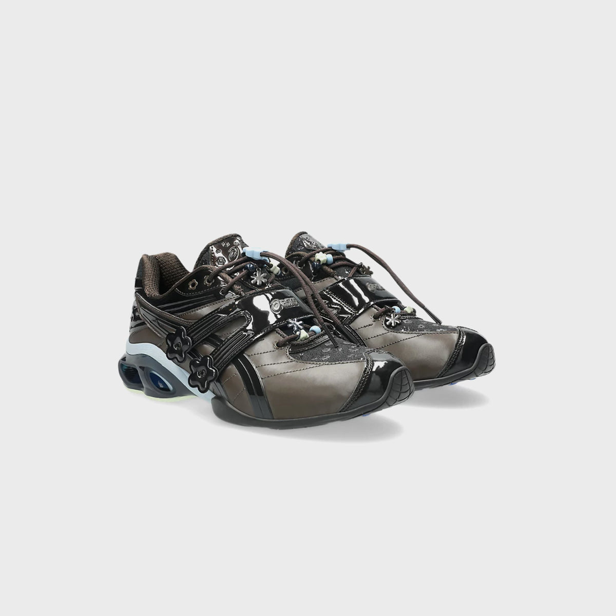 Pair of ASICS x Cecilie Bahnsen GEL-KINETIC FR sneakers in black coffee, angled front view with pastel floral lace charms