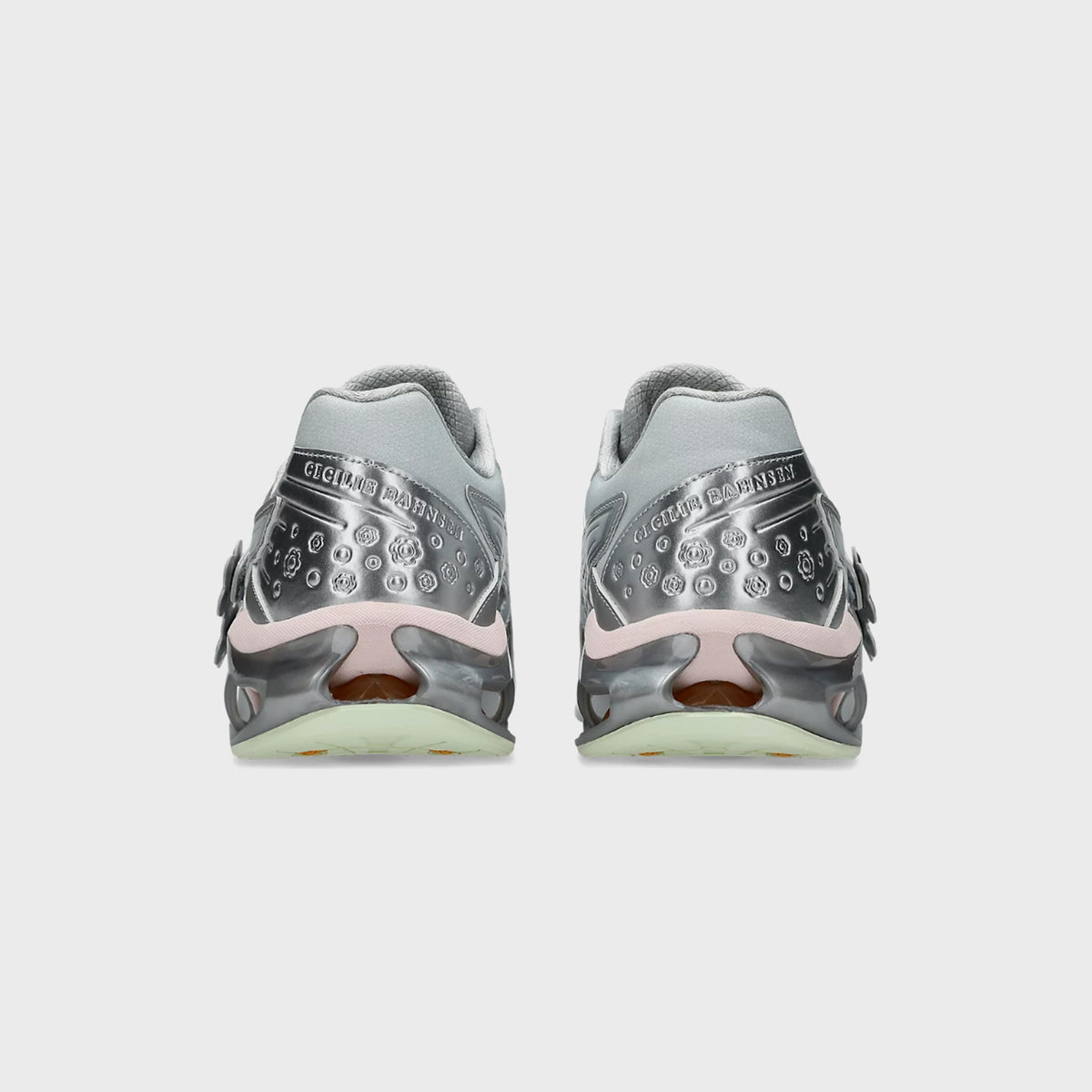 Heel view of ASICS x Cecilie Bahnsen GEL-KINETIC FR pair with embossed Cecilie Bahnsen script and debossed floral silver panel