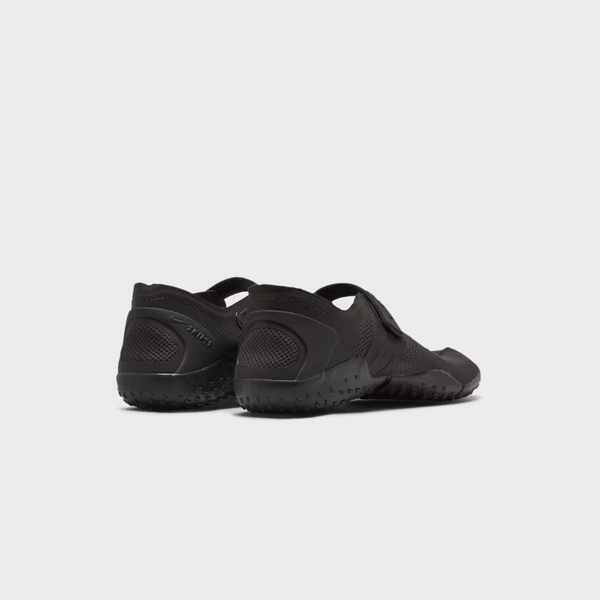 NikeSKIMS Rift 2 Tone Mesh sneakers in Tar Black, rear three-quarter view of the pair on a tonal lugged outsole