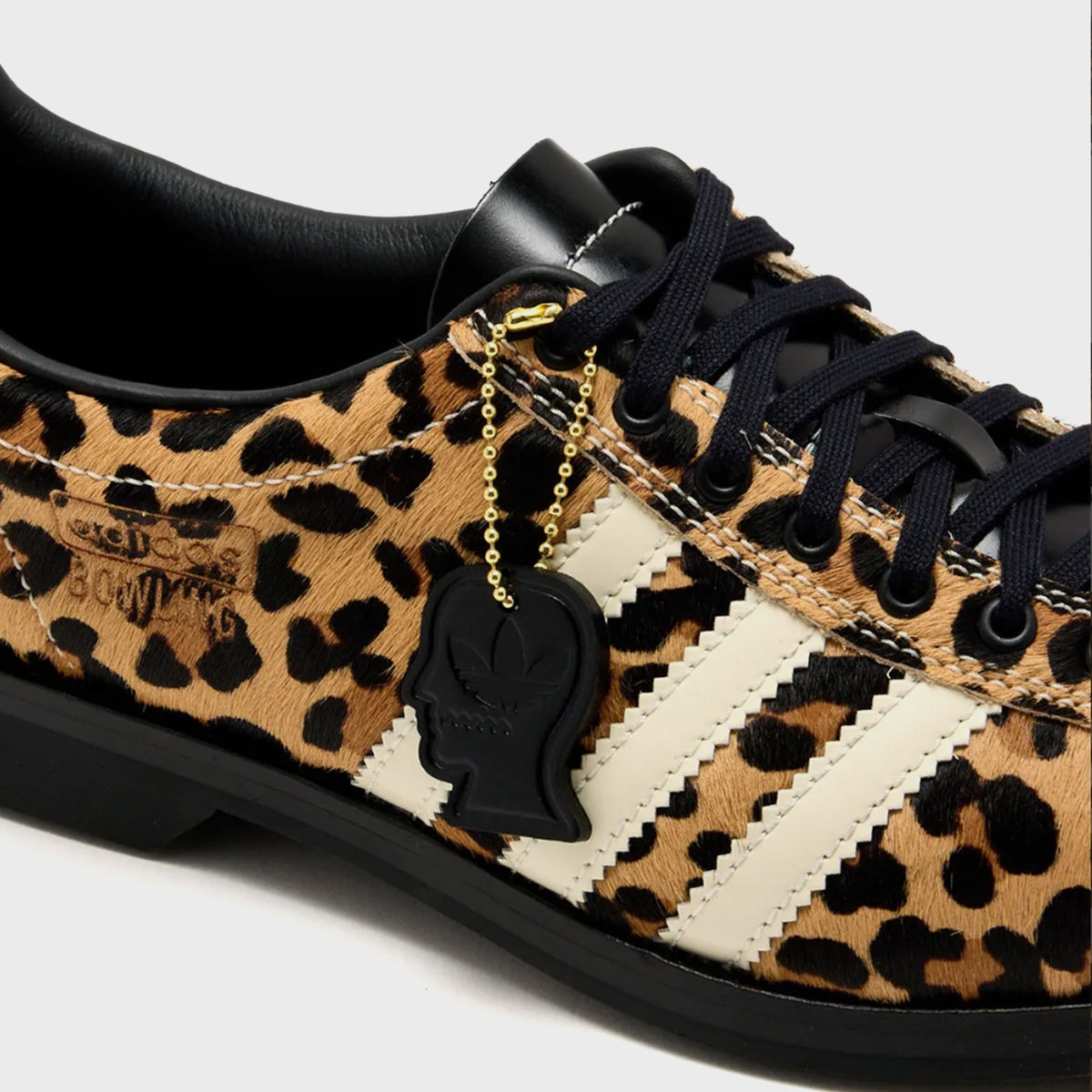 adidas x Brain Dead Samba Bowling shoe in Tan / Black / Cream leopard-print pony hair, close-up of laces, cream stripes and black head-shaped charm