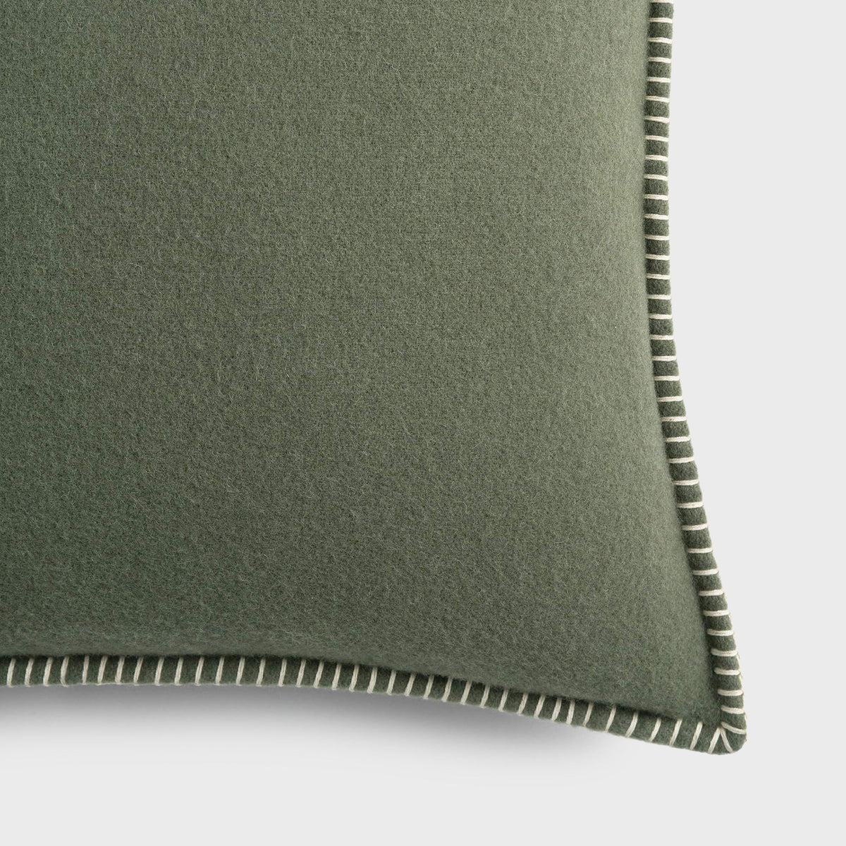 Tekla Lambswool Cushion in Willow, close-up of the sage green wool fabric and whipstitched edge