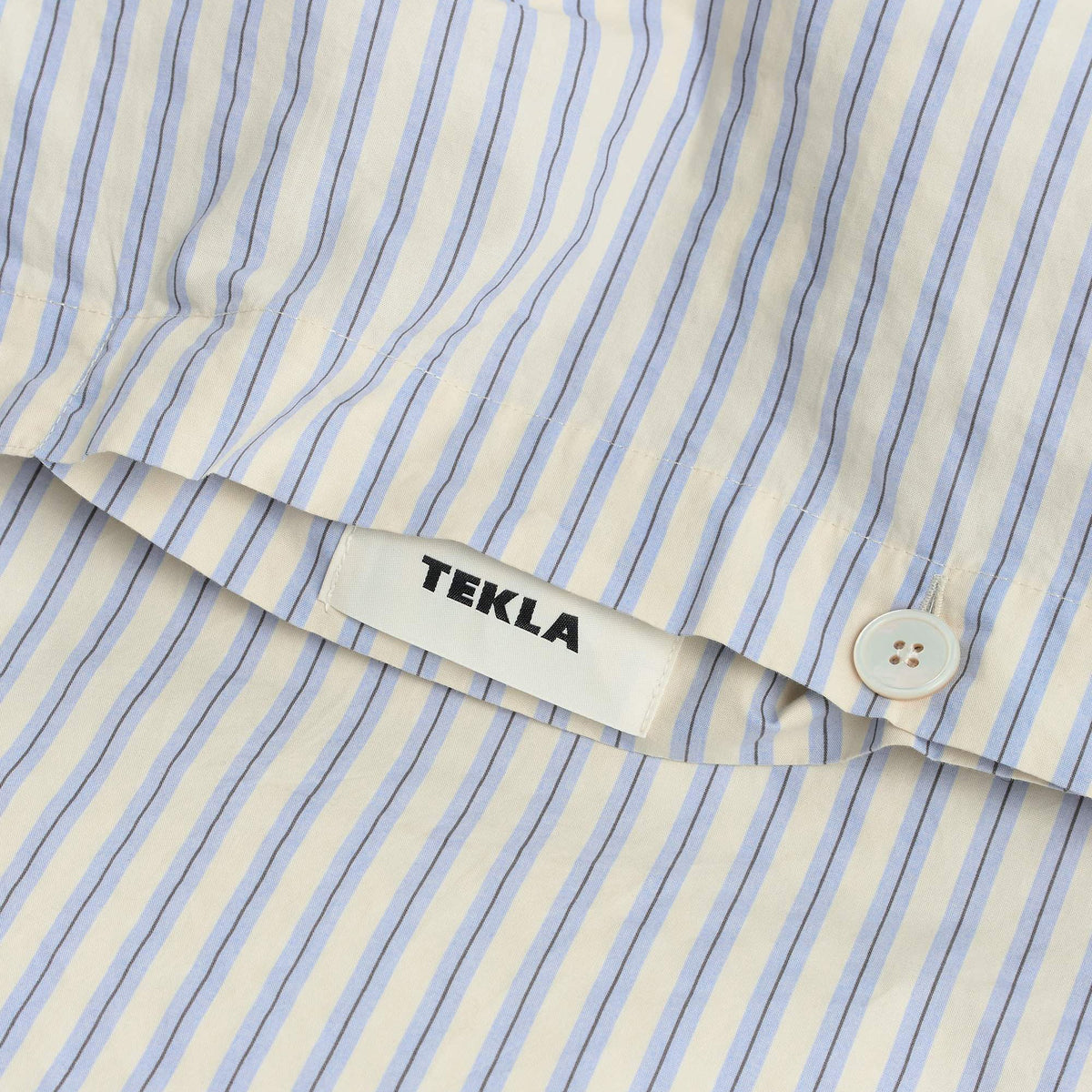 Tekla Percale Double Duvet Cover in Flint Stripes, close-up of corner with woven TEKLA label and button closure