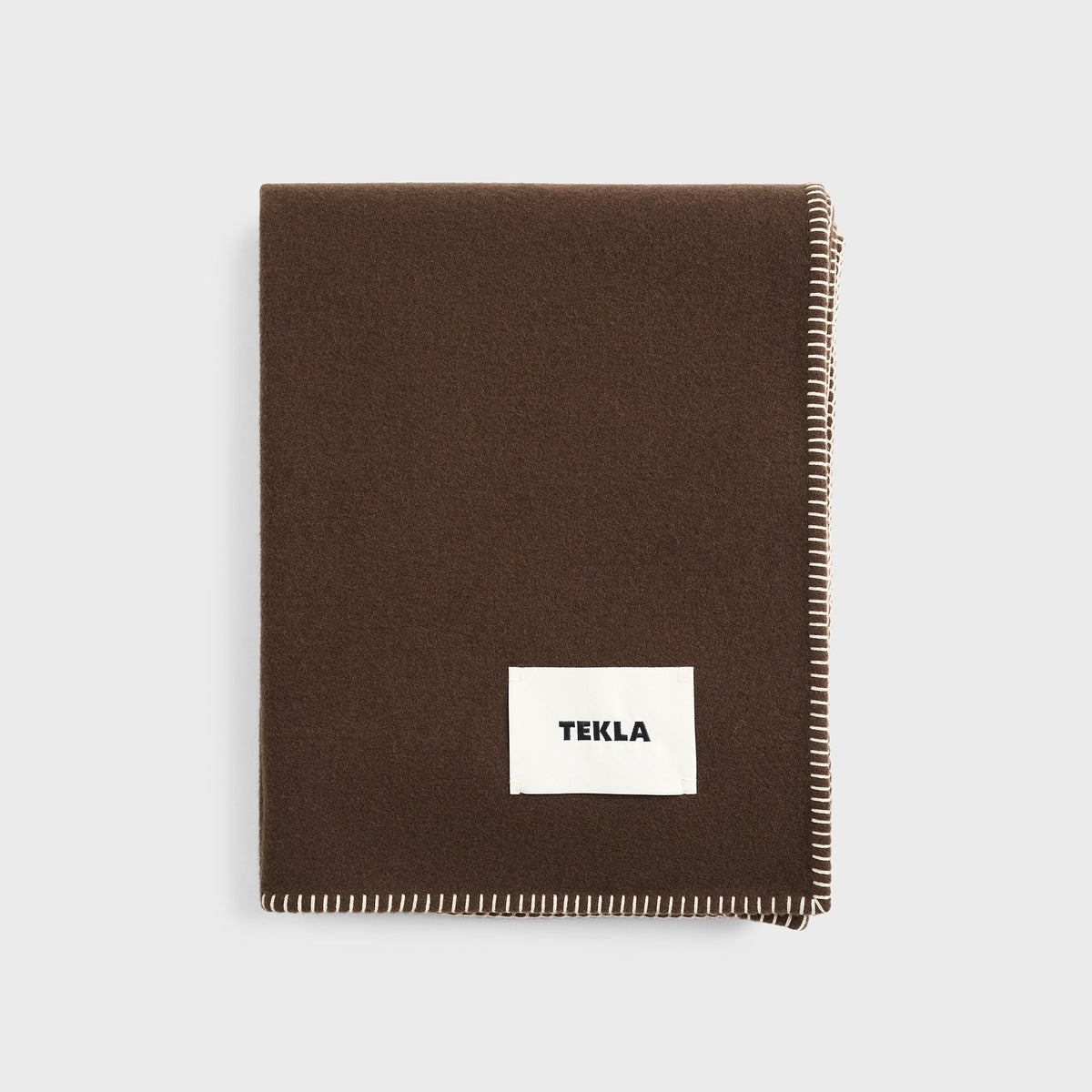 Tekla Lambswool Blanket in Walnut, folded dark brown wool blanket with TEKLA label