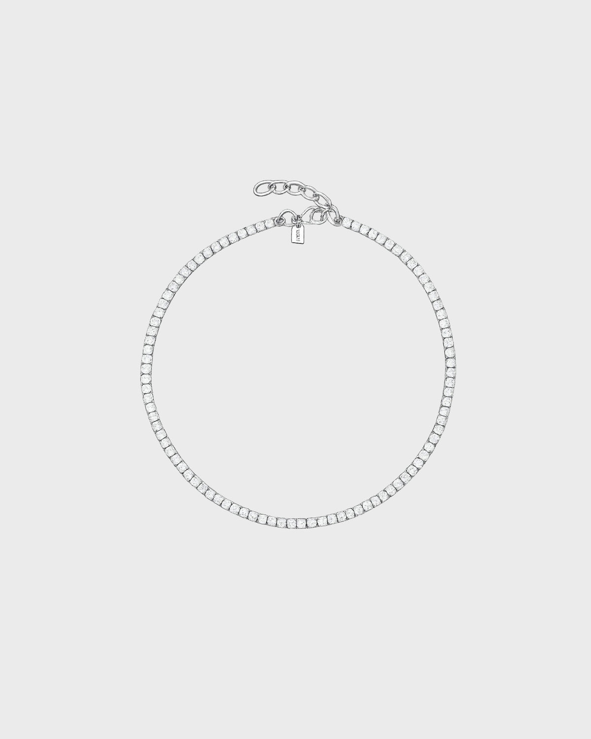 Crystal Haze silver crystal tennis necklace with small padlock charm and chain clasp on light gray