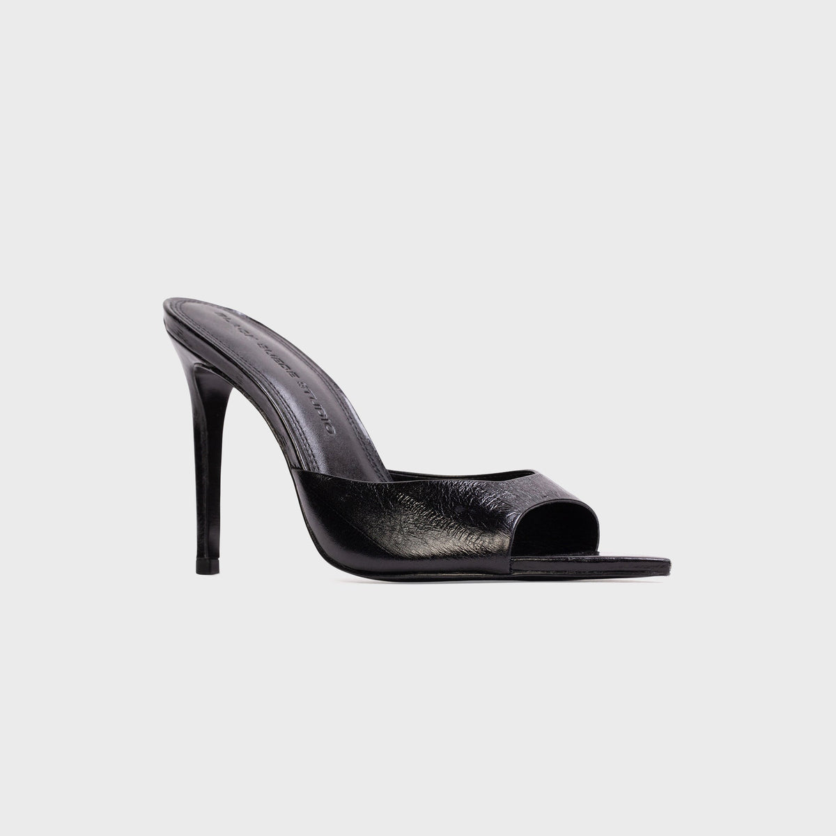 Black Suede Studio Brea Mule in Black Eel (black embossed leather), three-quarter view with stiletto heel and open toe