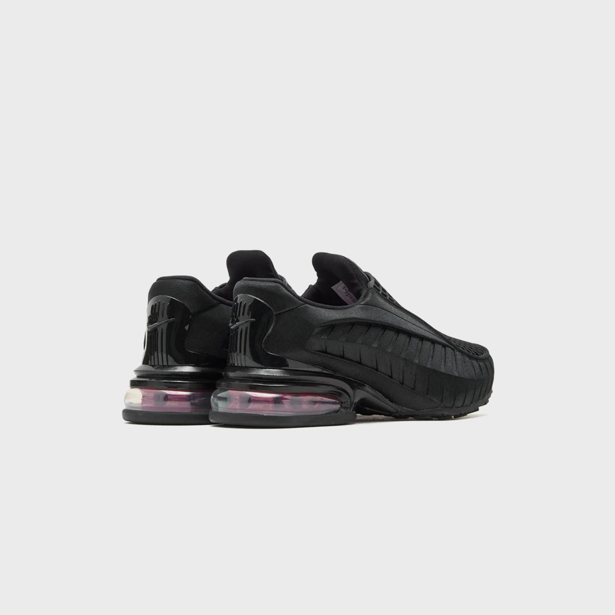 Nike WMNS Air Max Dolce Black / Sport Red pair, rear three-quarter view of black slip-on with visible pink Air Max heel unit